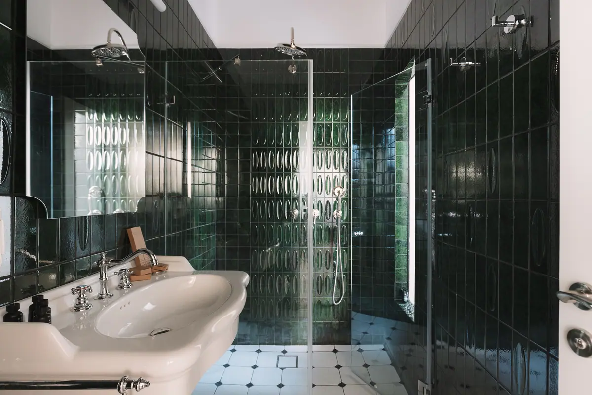 A private bathroom with dark green tiles