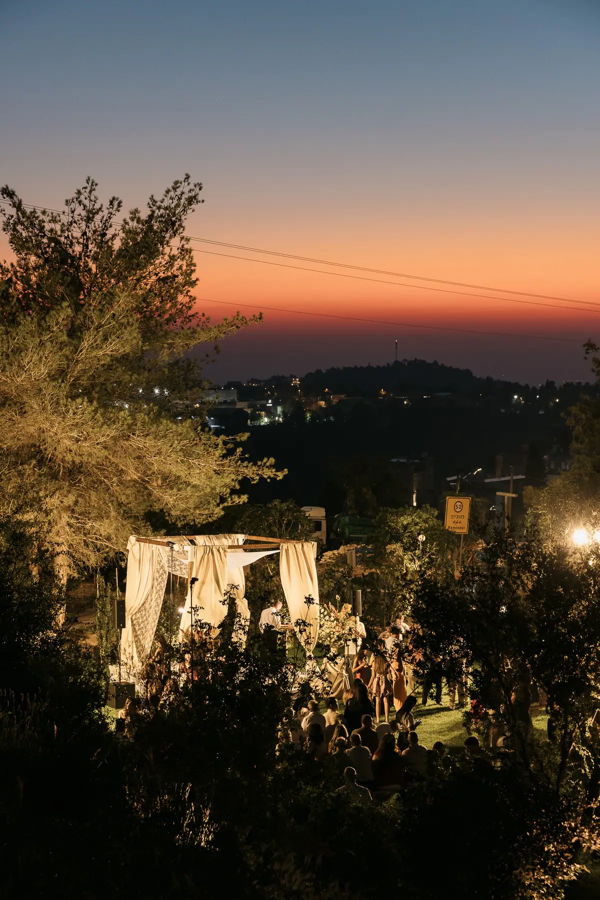 The chuppah with the lights of the hills behind